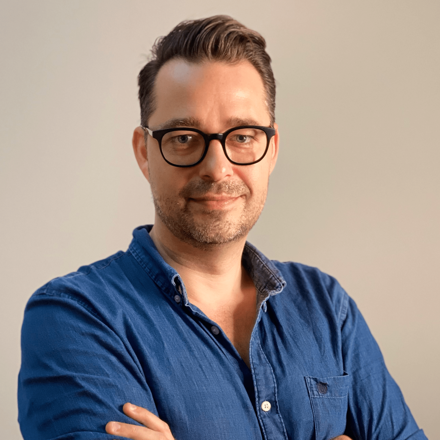 Head shot, Bjorn wearing glasses and a blue denim shirt