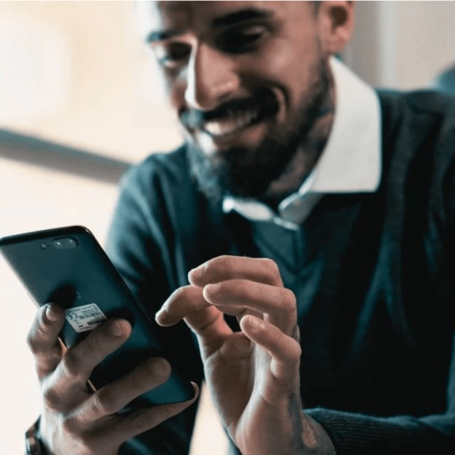 Man looking at his phone while smiling